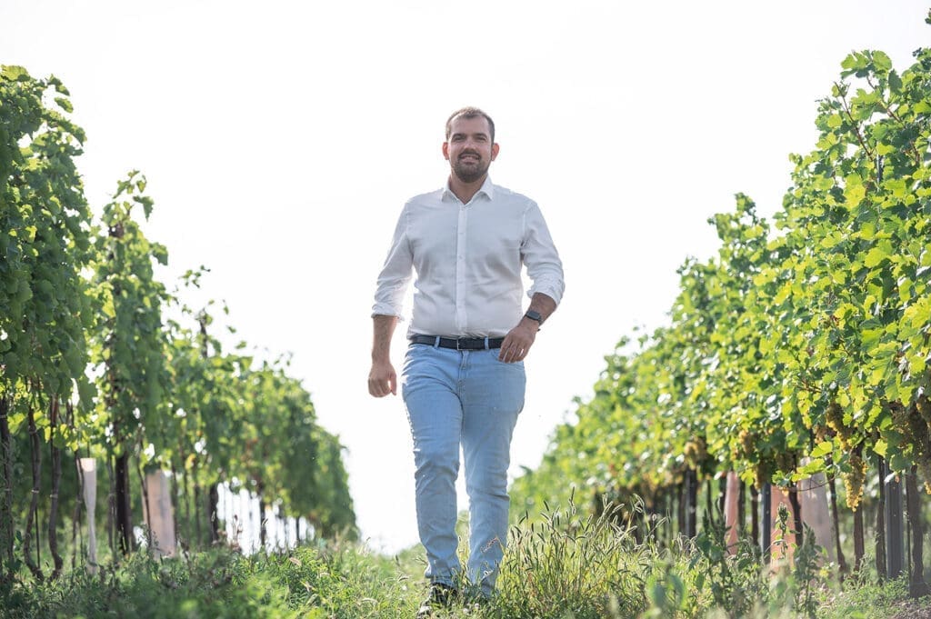 Bürgermeister Kilian Brandstätter mit weißen Hemd, heller Jeans und Gürtel im Weingarten.